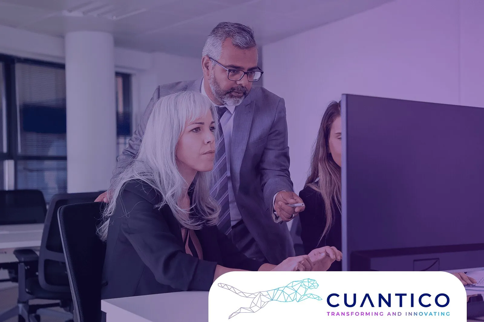 Grupo de líderes empresariales en mesa de trabajo digital, planificando estrategias apoyadas por inteligencia artificial y analítica de datos. Logo de CUANTICO